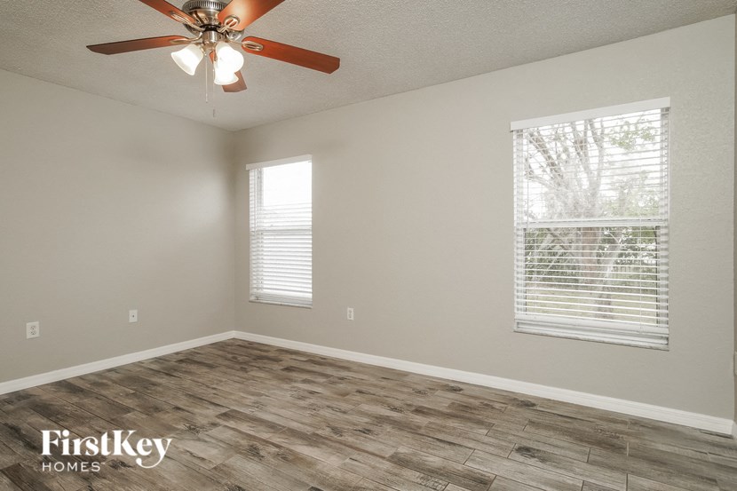 a living room with wood floors and a ceiling fan
