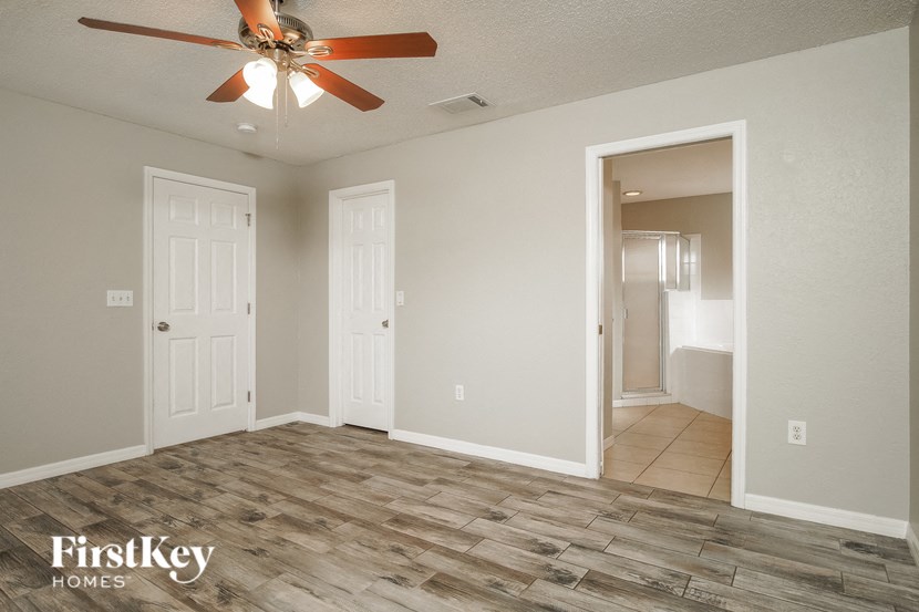 the living room of an empty house with a ceiling fan