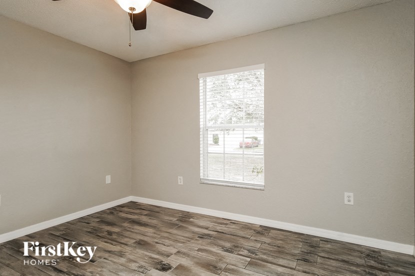 a bedroom with a window and a ceiling fan
