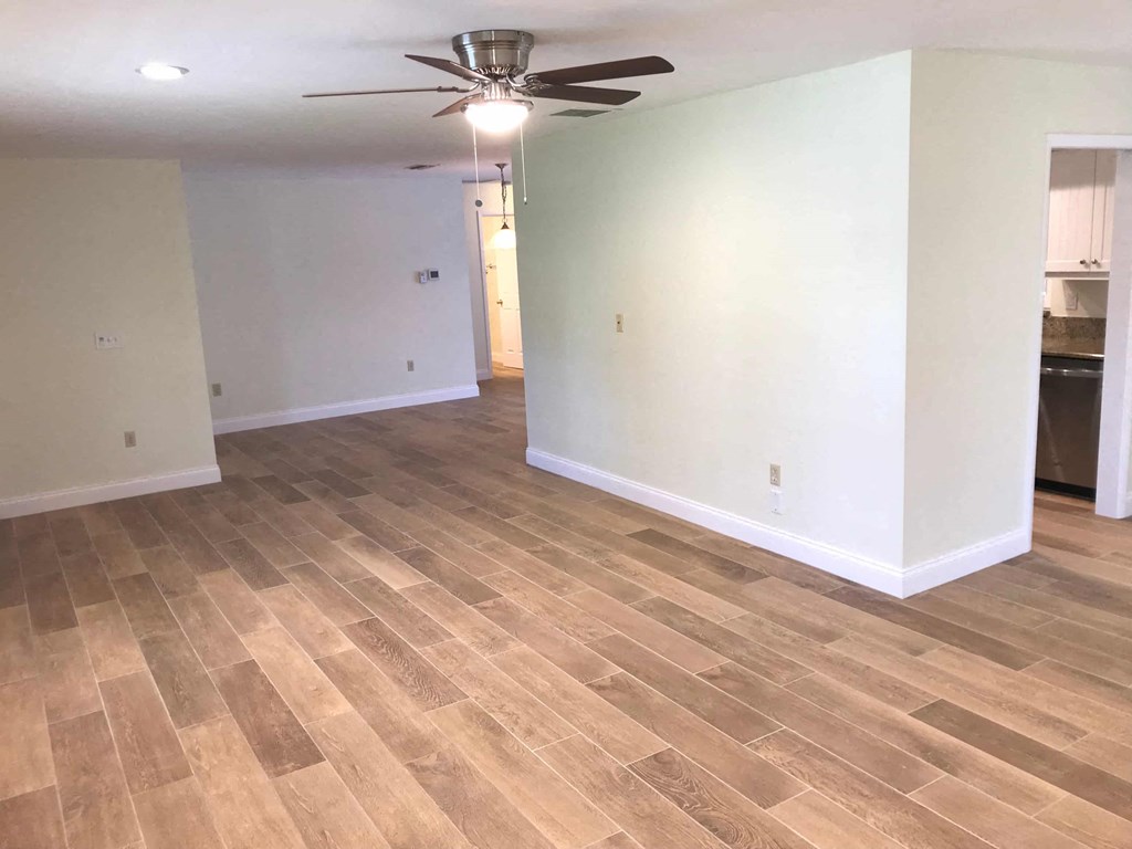 a living room with a hard wood floor and a ceiling fan