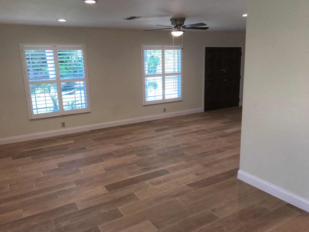 a living room with wood flooring and a ceiling fan