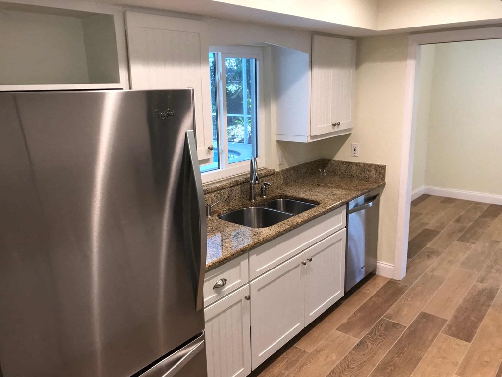 a kitchen with white cabinets and a stainless steel refrigerator