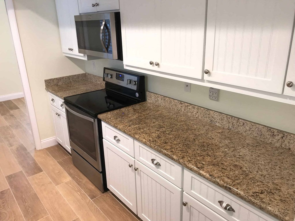 a kitchen with granite counter tops and white cabinets