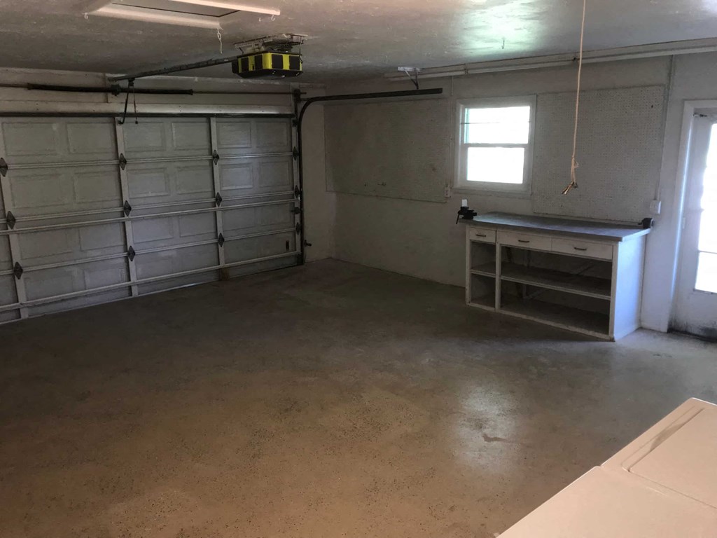 an empty garage with white cabinets and a counter