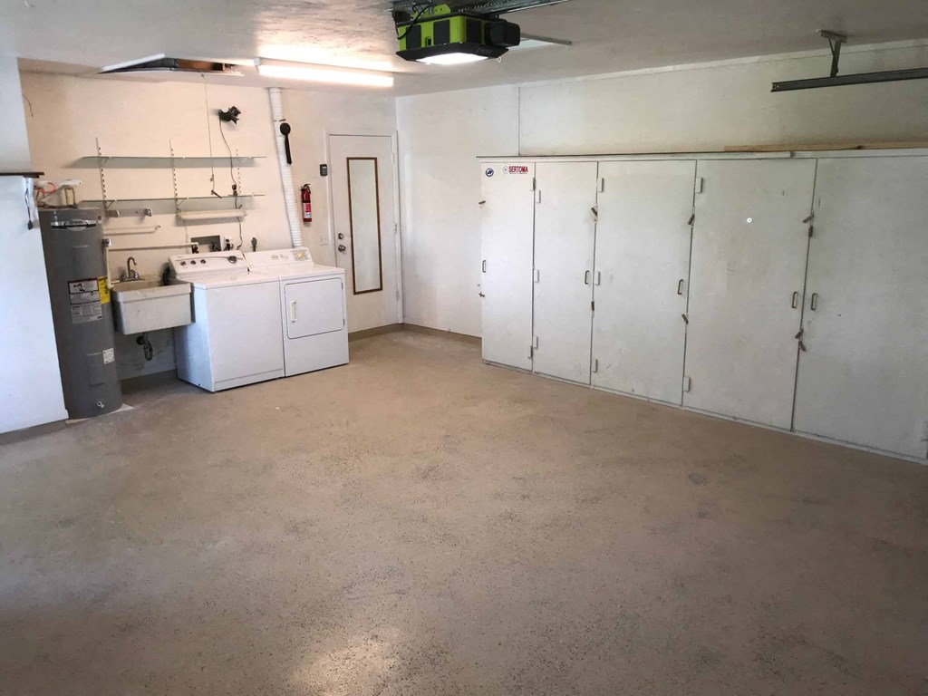 a large room with white cabinets and appliances in it