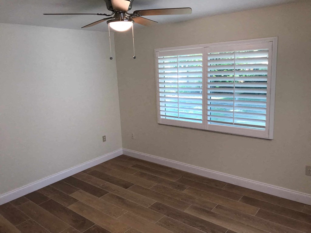 a living room with a ceiling fan and a window