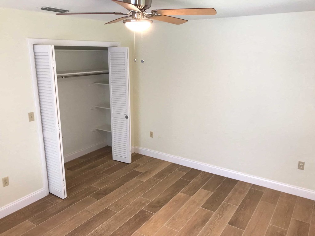 a bedroom with a closet and a ceiling fan