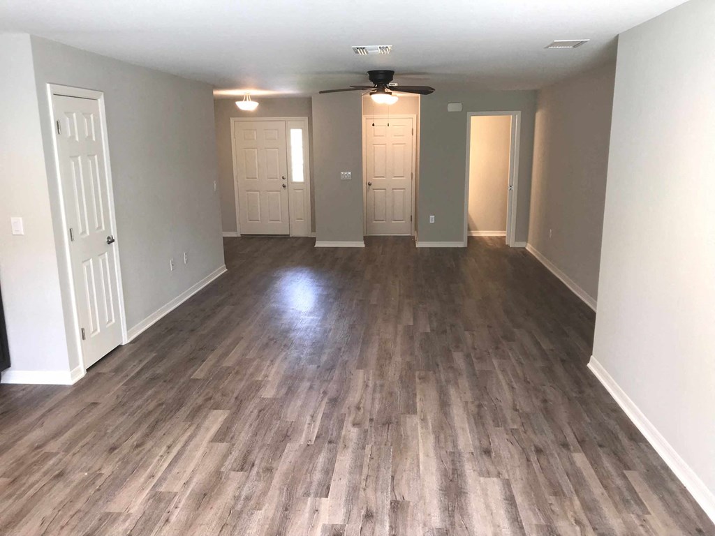 A room with wooden flooring and a ceiling fan.