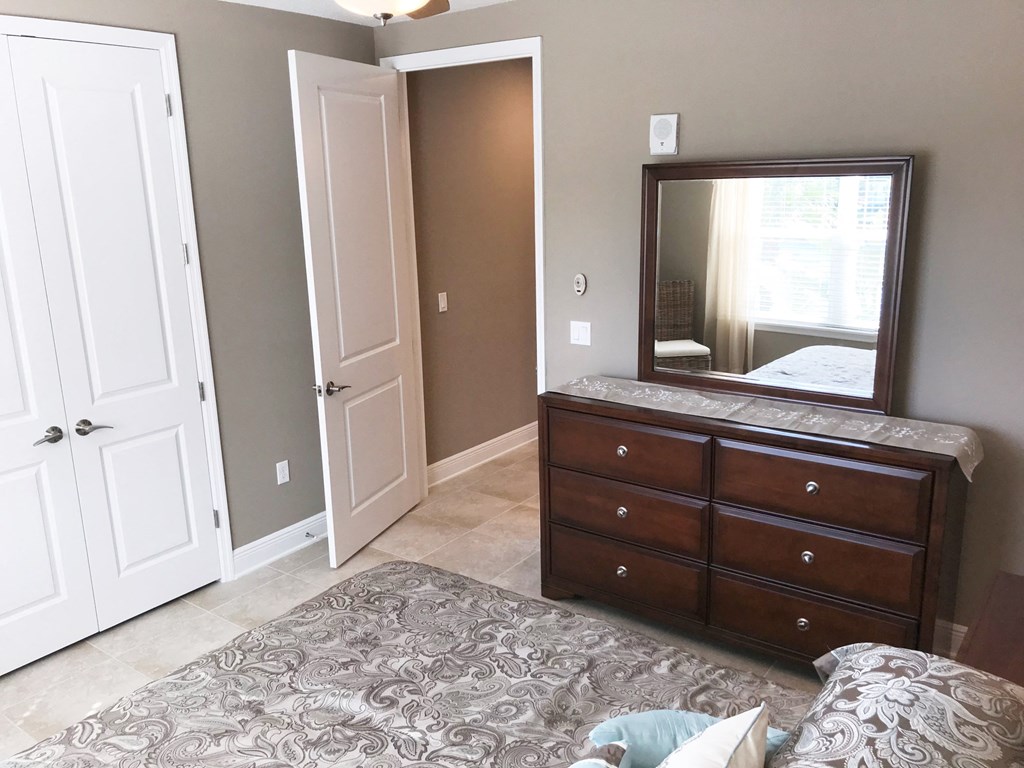 a bedroom with a dresser and a mirror in it
