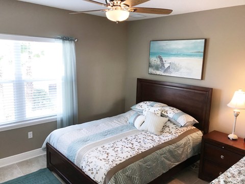 a bedroom with a bed and a ceiling fan
