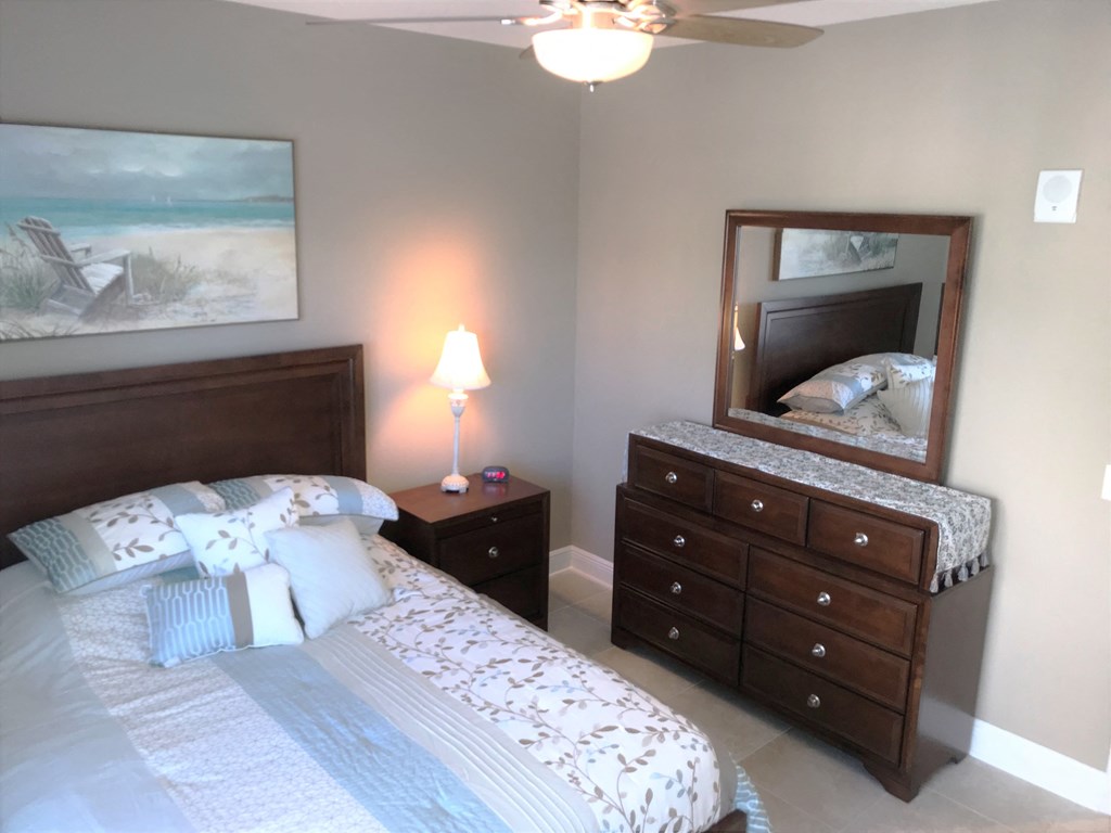 a bedroom with a bed and a dresser with a mirror