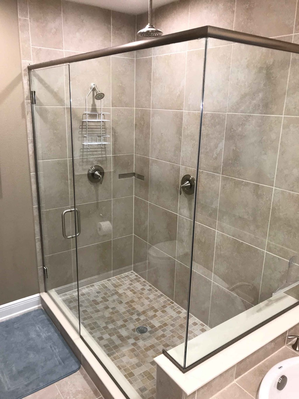 a large shower with a glass door in a bathroom