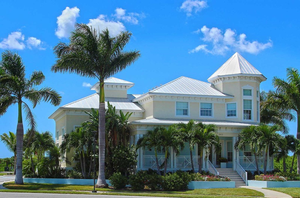 a large white house with palm trees in front of it