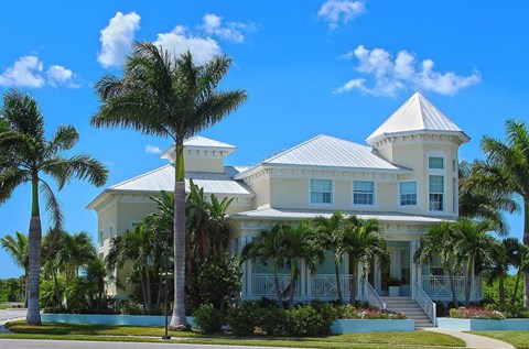 a large white house with palm trees in front of it