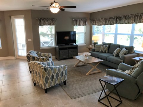 a living room with couches and chairs and a tv
