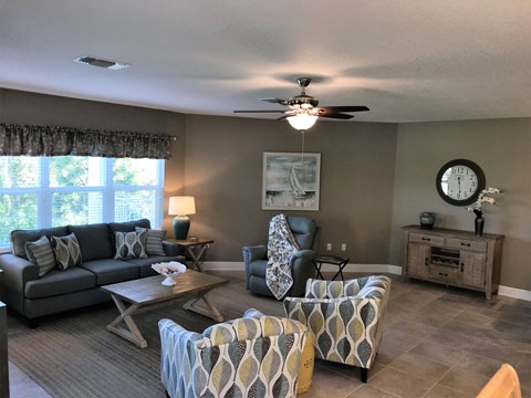 a living room with couches and chairs and a clock on the wall