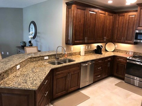 a kitchen with granite counter tops and wooden cabinets