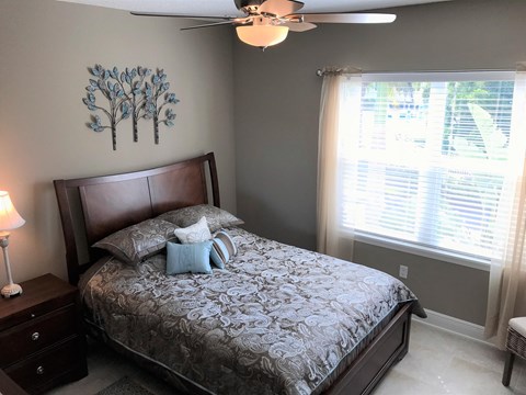 a bedroom with a bed and a ceiling fan