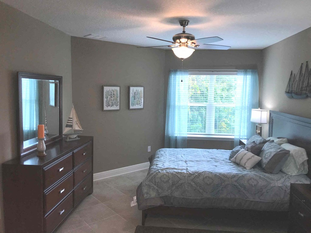 a bedroom with a bed and a ceiling fan