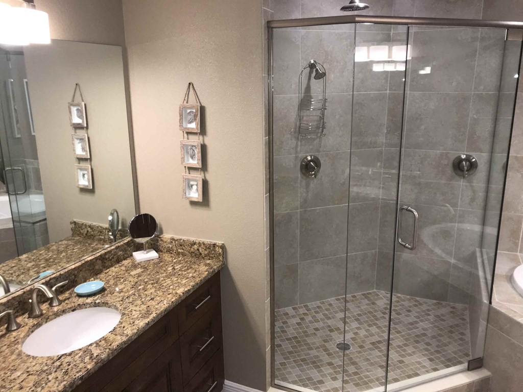 a bathroom with a shower and a sink and a mirror