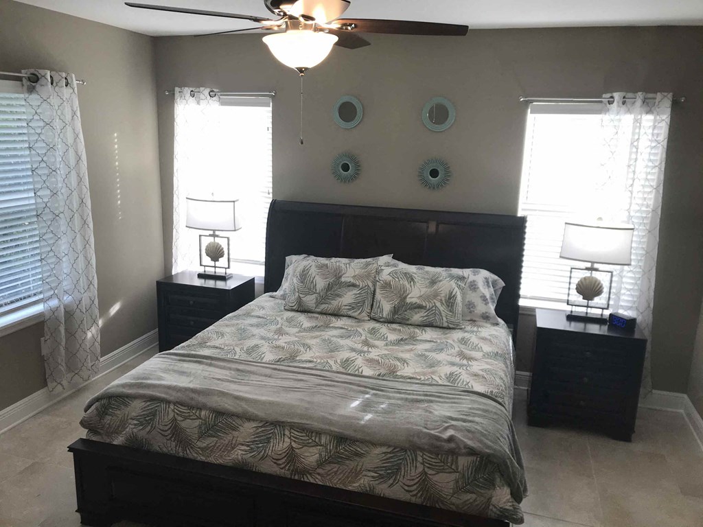 a bedroom with a bed and a ceiling fan
