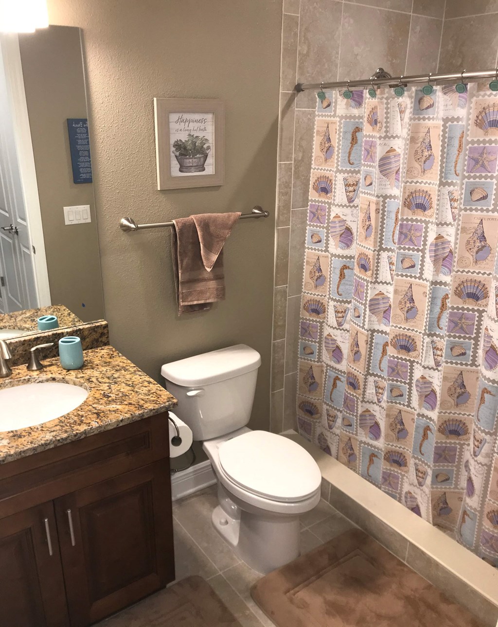 a bathroom with a toilet and a sink and a shower curtain