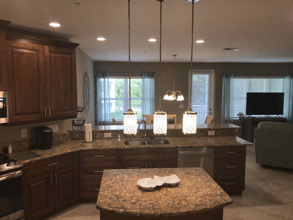 a large kitchen with granite counter tops and dark wood cabinets