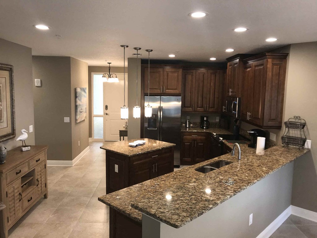 a large kitchen with granite counter tops and stainless steel appliances