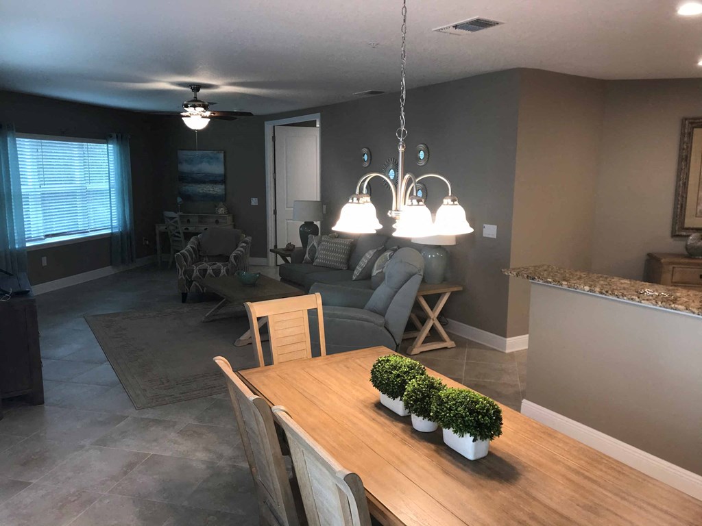 a dining room and living room with a table and chairs