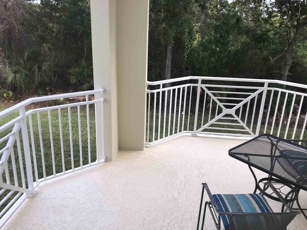 a balcony with a table and chairs on it