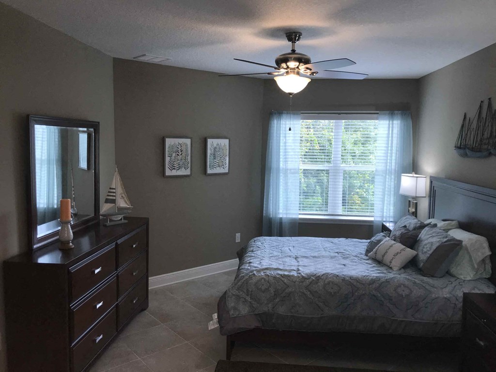 a bedroom with a bed and a ceiling fan