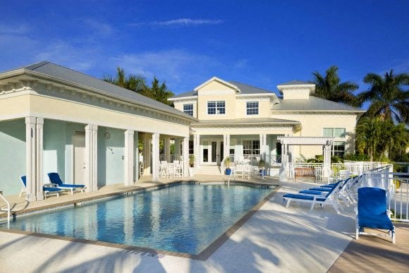 a large swimming pool in front of a large house