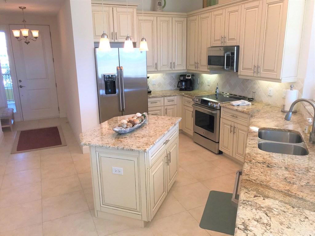 a kitchen with white cabinets and granite counter tops