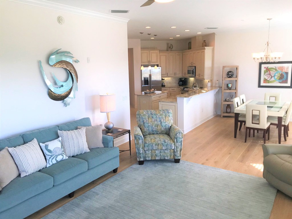 a living room with a couch and a chair and a kitchen