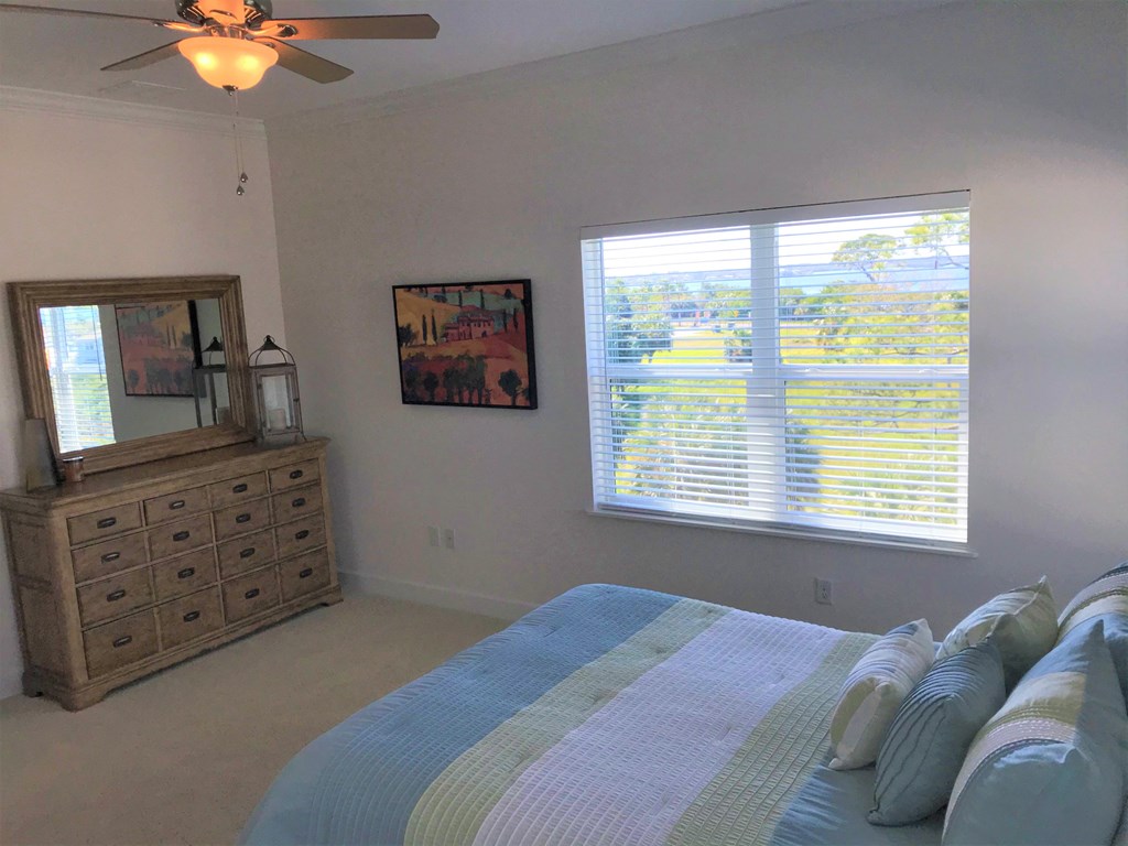 a bedroom with a bed and a dresser and a window