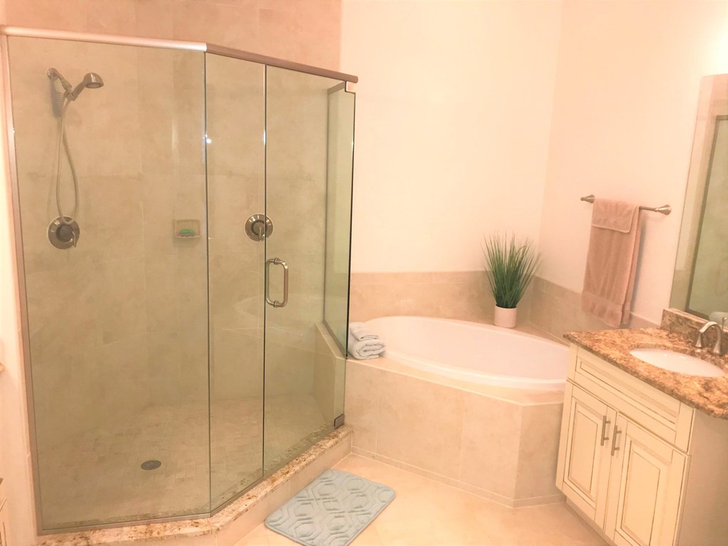 a bathroom with a shower and a tub and a sink