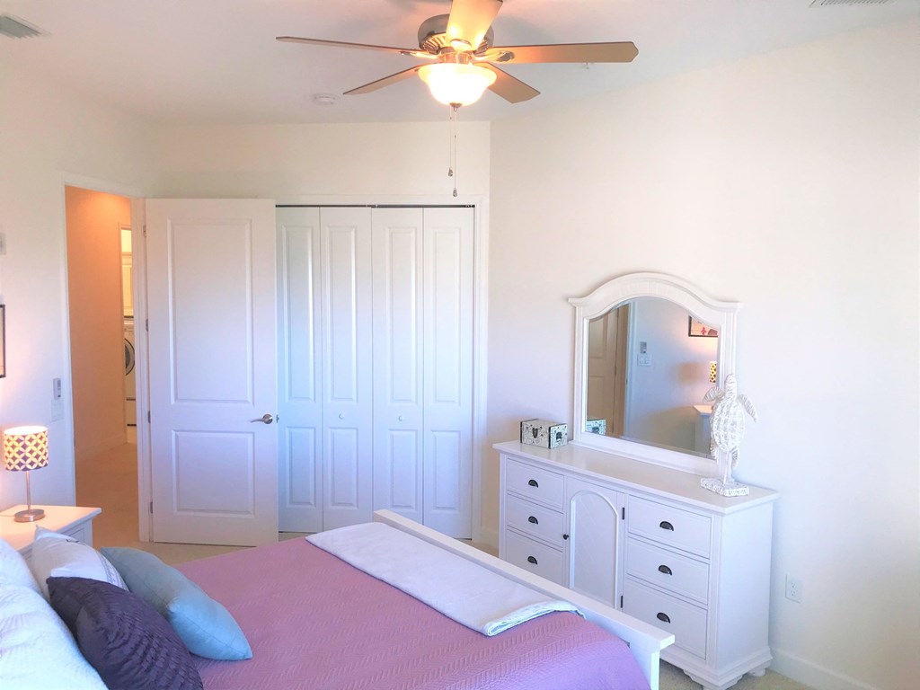 a bedroom with a bed and a dresser with a mirror