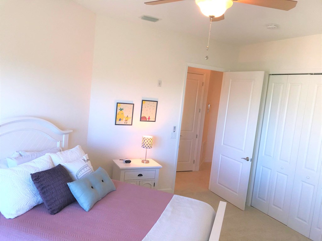 a bedroom with a bed and a night stand and a closet