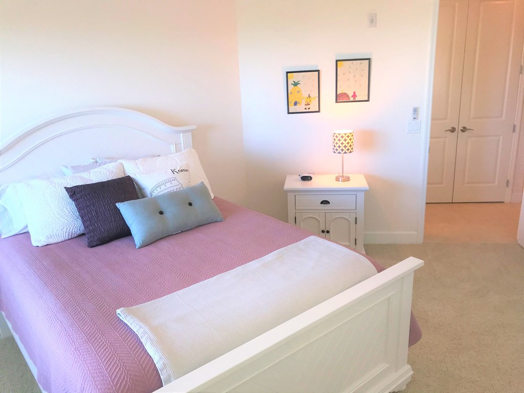 a bedroom with a bed and a night stand with a lamp