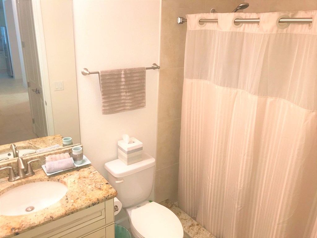 a bathroom with a toilet and a sink and a shower