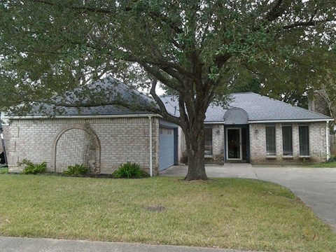 a brick house with a tree in front of it