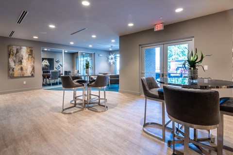 a clubhouse with a bar and chairs and a glass table