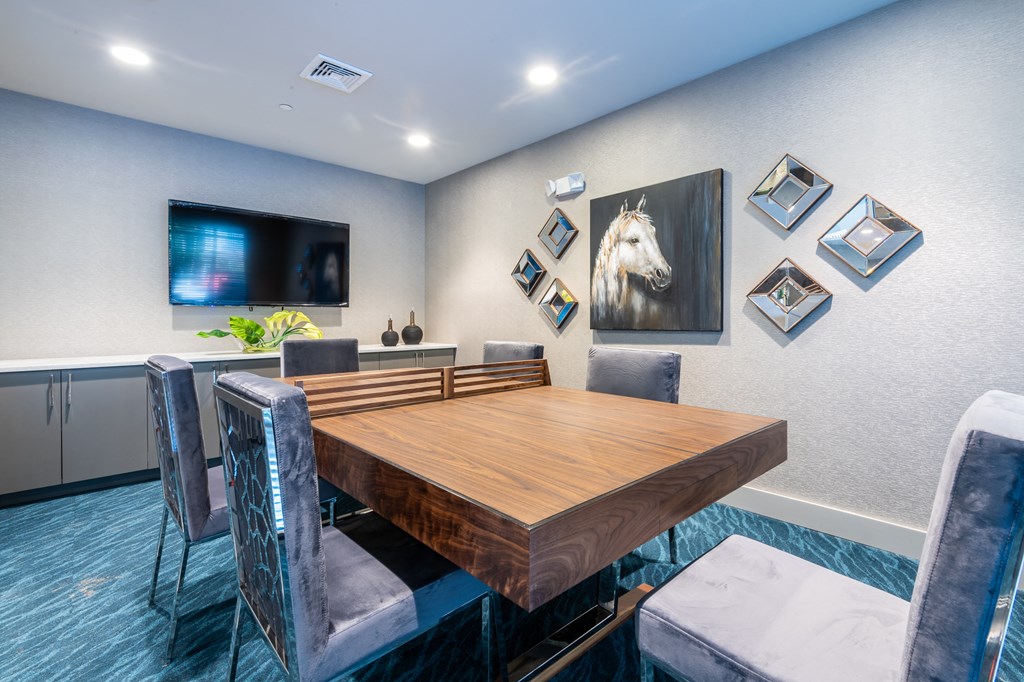 a dining room with a table and chairs and a tv on the wall