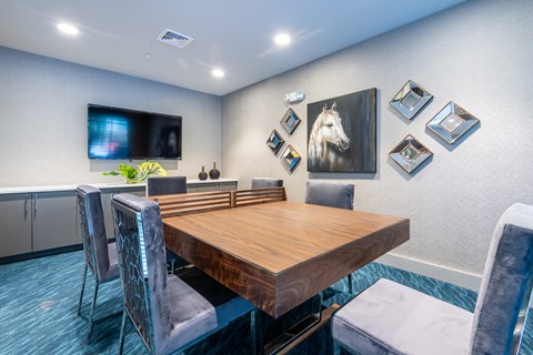 a dining room with a table and chairs and a tv on the wall