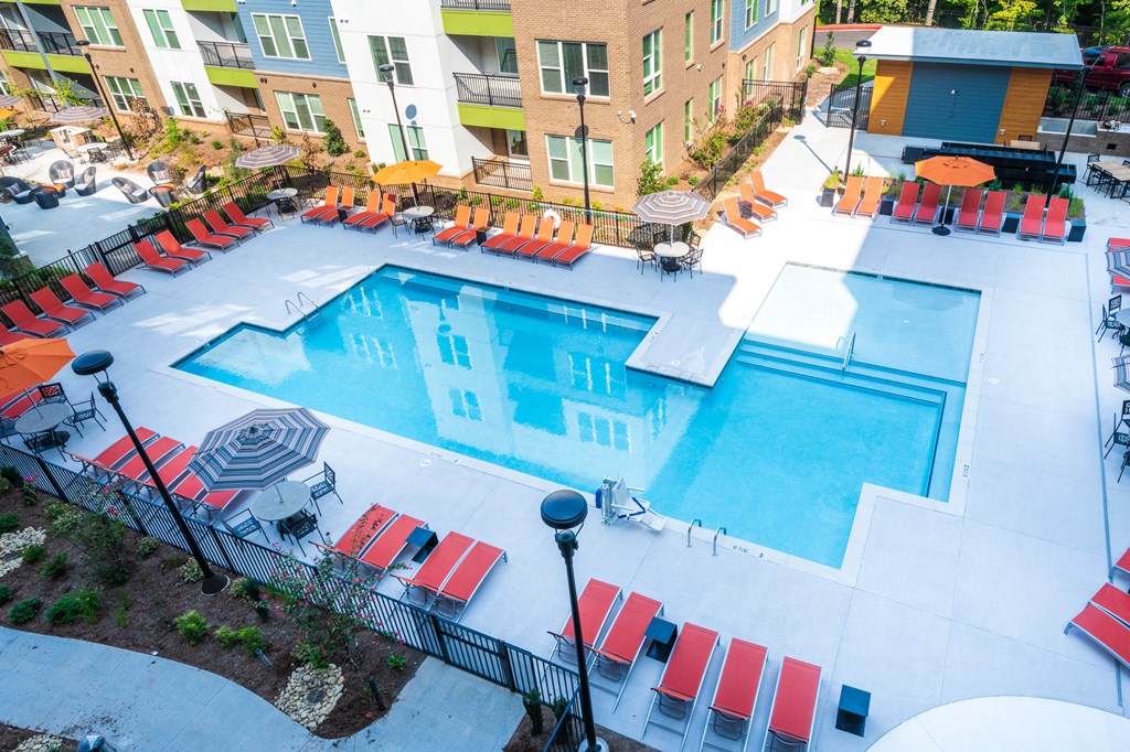 an aerial view of a swimming pool at a hotel with red chairs