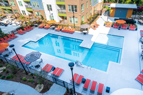 an aerial view of a swimming pool at a hotel with red chairs
