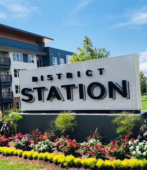 a sign for district station in front of a building