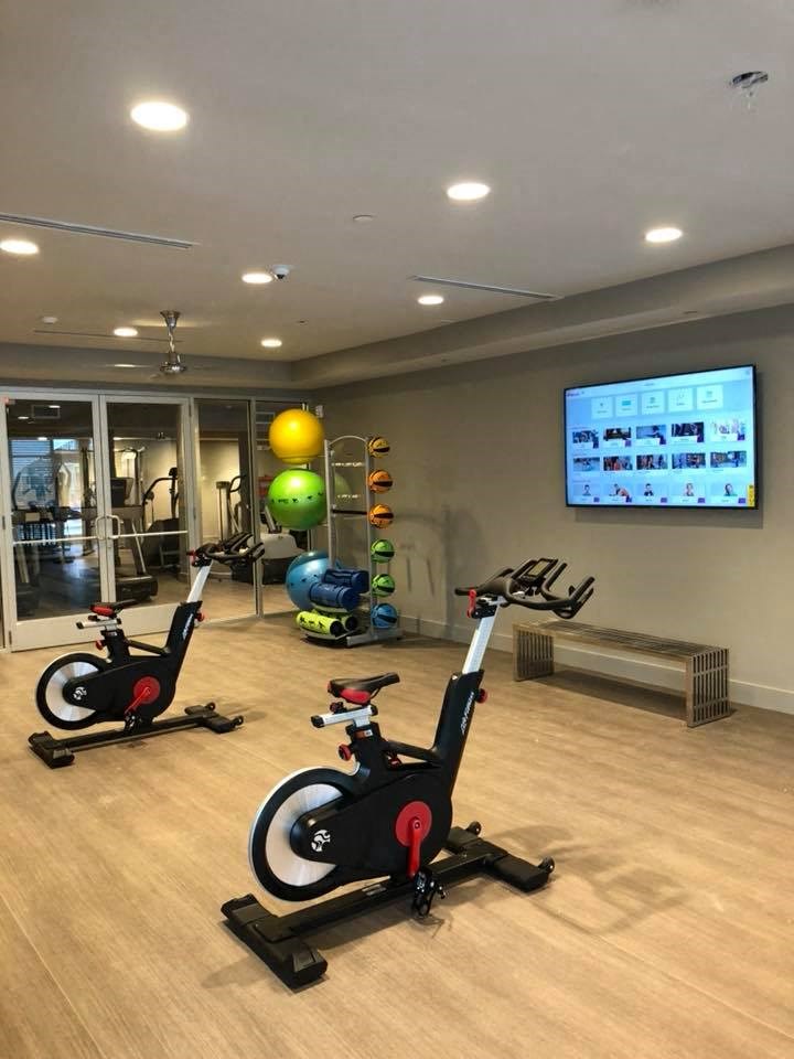a gym with two exercise bikes and a tv on the wall