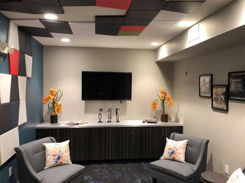 a lobby with two chairs and a sink and a television