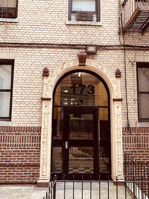 the front of a brick building with a glass door